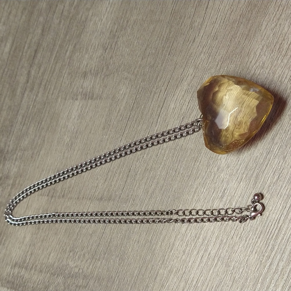 Clear Amber Heart with Silvertone Chain. Has extender.